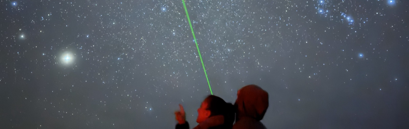 Guests watching a guide trace the night sky with a green laser on a Bryce Canyon Stargazing tour